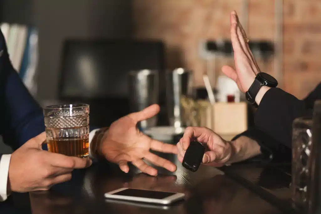 Someone with a drink in their hand asking for car keys.